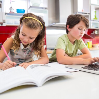 girl-doing-her-homework-while-boy-using-laptop-in-JBYED68.jpg